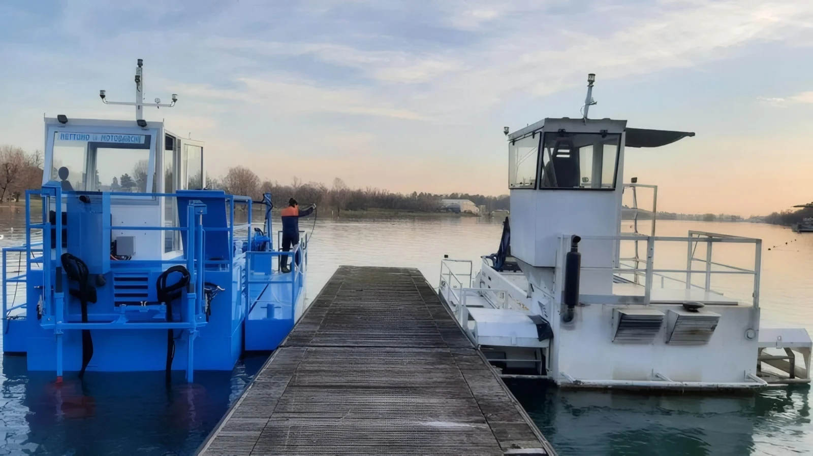 Due motobarche raccogli-alghe Nettuno modello CHUB ormeggiate al pontile al tramonto