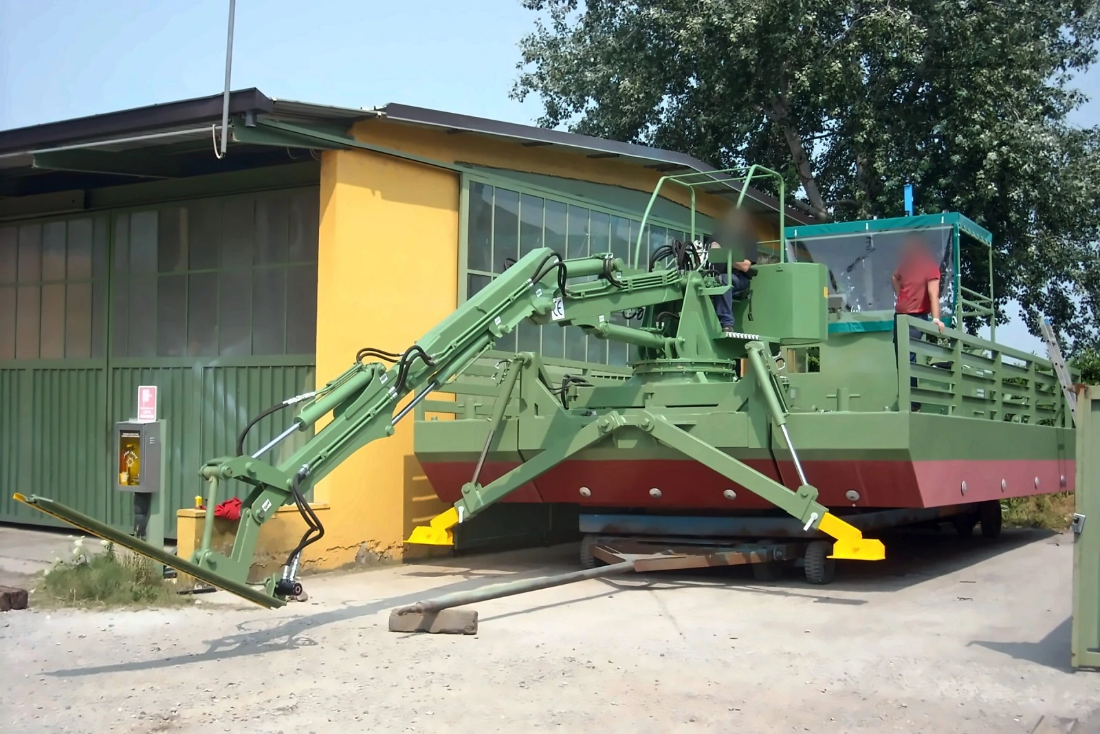 Braccio escavatore con installata barra falciante, piedi stabilizzatori e postazione di comando a poppa, in cantiere — Draghe Nettuno